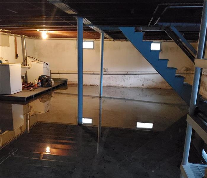 water in basement flood reflecting lights, washer and dryer there