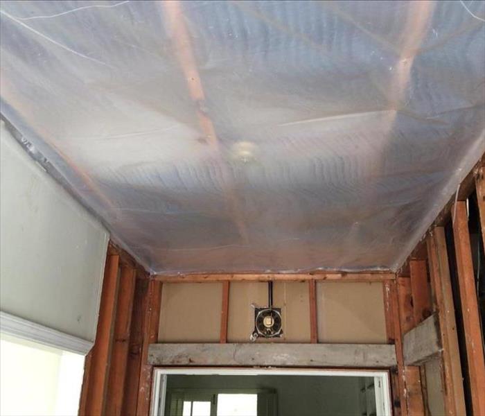 polyethylene sheeting on the ceiling, exposed wall studs and framing
