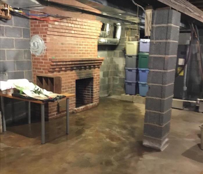  basement, with a wet floor and a brick fireplace