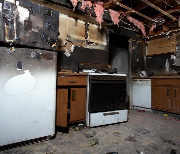 A kitchen with fire and soot damage.
